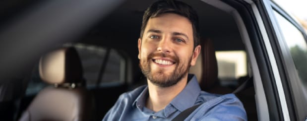 Man smiling in car