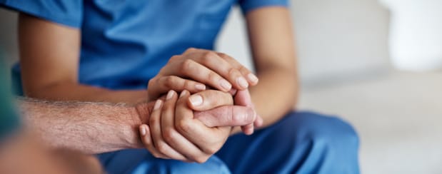 Doctor holding his patient hand